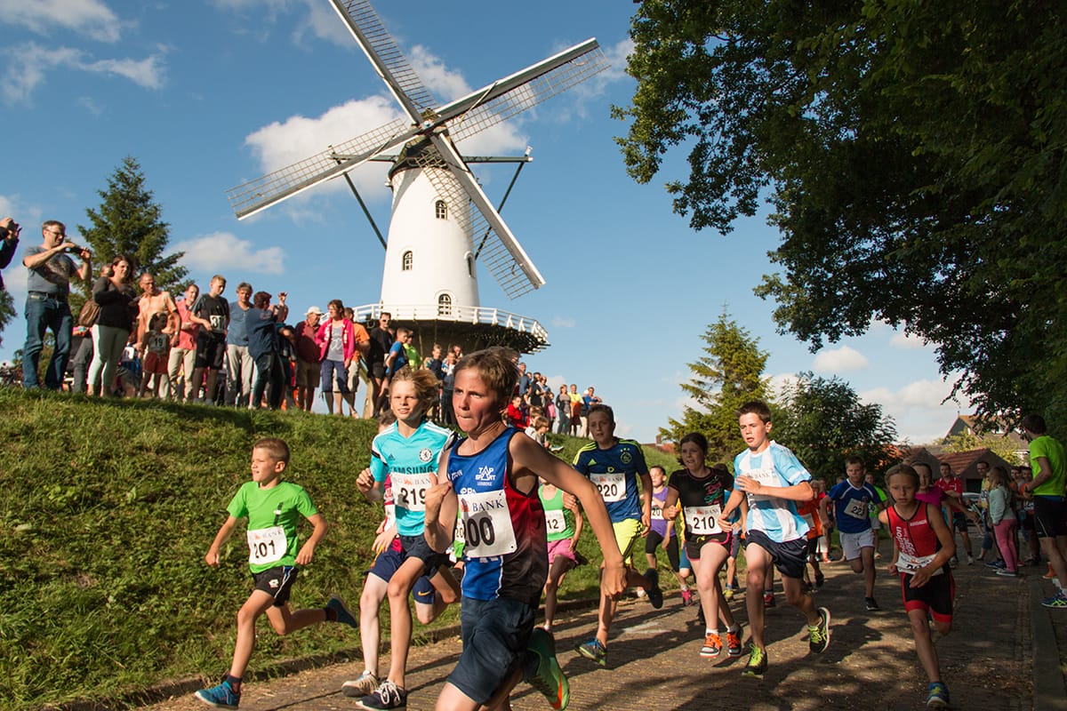 Molen De Witte Juffer op de wal, met hardlopers op de voorgrond